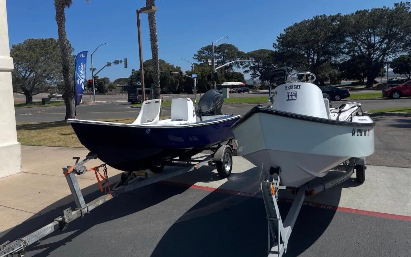 Two Del Mar boats on trailers by the water